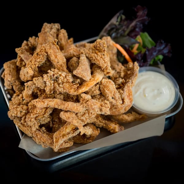 Crispy vegan fried oyster mushrooms with a side of ranch dressing and mixed greens.